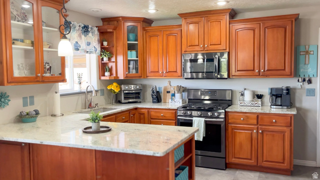1797 Sunset Road Enoch, UT 84721 - Photo 12 of 80 Kitchen featuring wood cabinetry, stainless steel appliances, light-toned countertops, and an integrated kitchen island