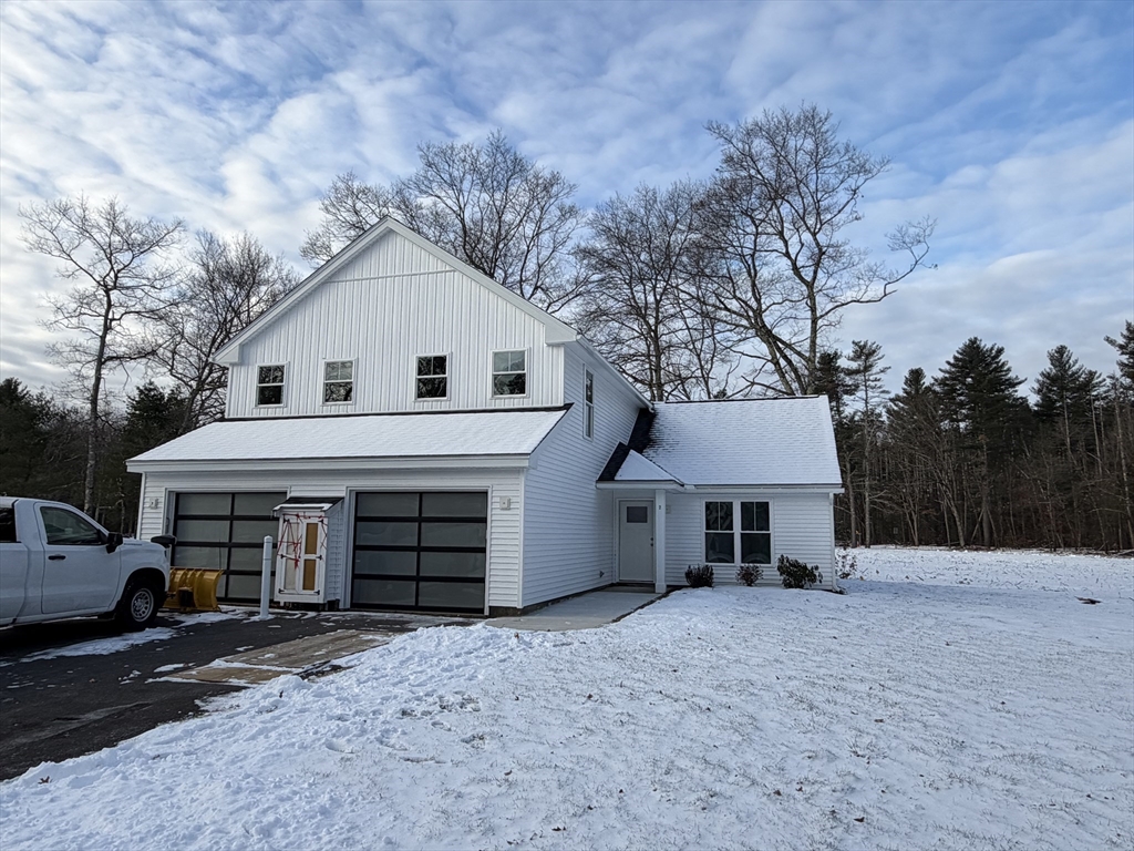 2 Barracks Road, Unit 2 Hudson, MA 01749 - Photo 1 of 12 a front view of a house with a yard and garage