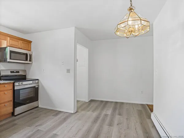 a view of a kitchen with wooden floor and stainless steel appliances