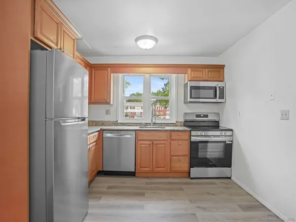 a kitchen with stainless steel appliances granite countertop a refrigerator sink and stove