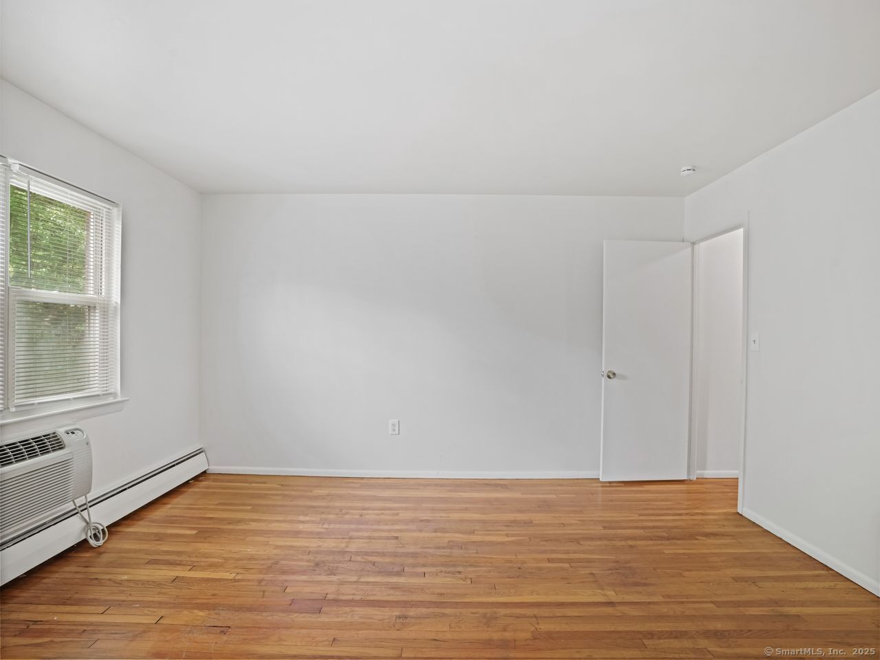 85 Abner Court, Unit 85 Bridgeport, CT 06606 - Photo 25 of 31 a view of an empty room with wooden floor and a window