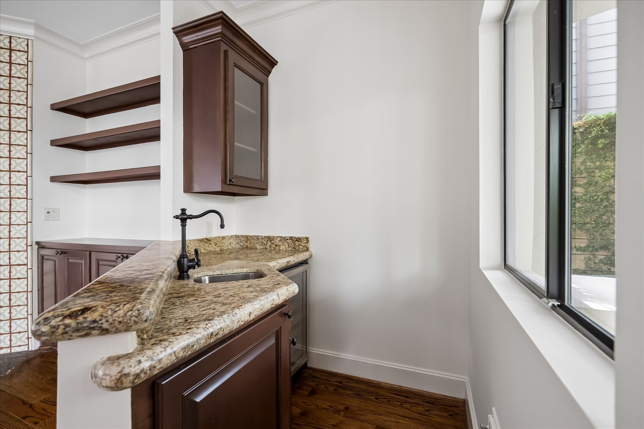2246 Branard Street Houston, TX 77098 - Photo 19 of 40 Well-positioned wet bar with granite countertops, custom cabinetry, and seamless connection to the patio and grill area.