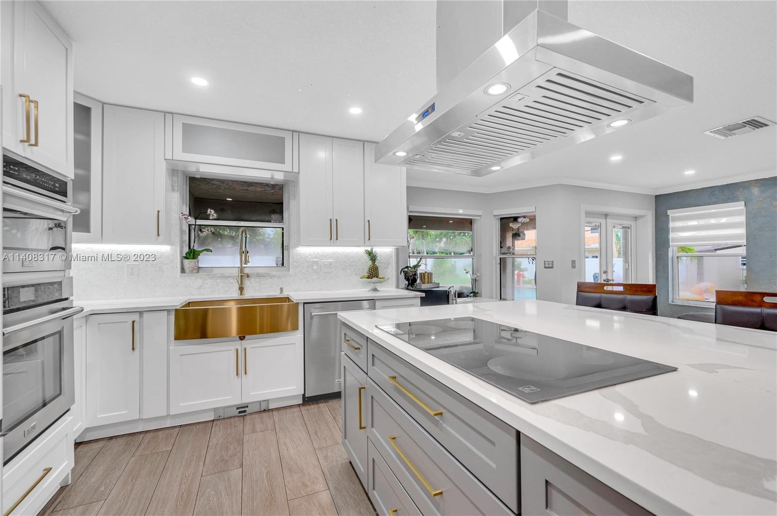 a kitchen with stainless steel appliances granite countertop a sink and white cabinets