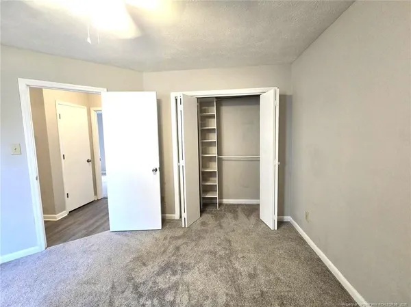 an empty room with closet and mirror