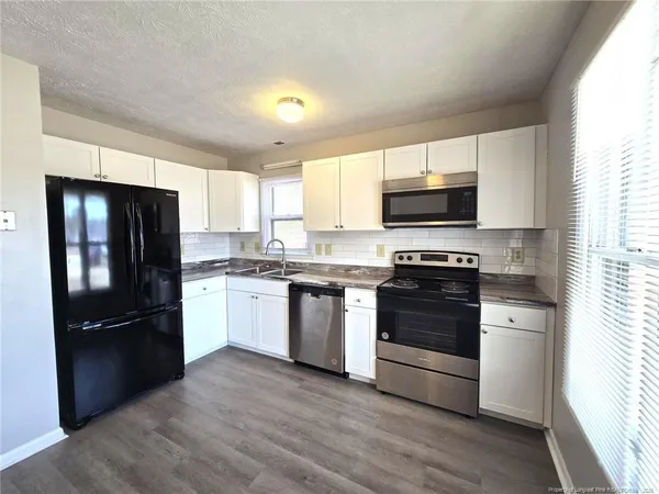 a kitchen with a refrigerator stove and microwave