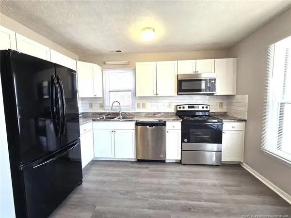 a kitchen with a refrigerator stove and microwave
