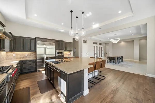 a kitchen with kitchen island a stove a sink a refrigerator and chairs