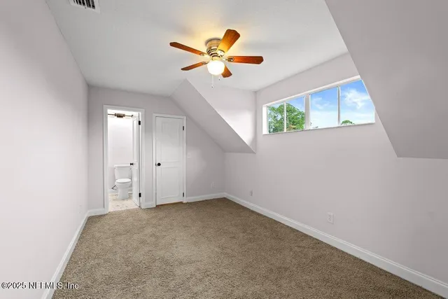 an empty room with ceiling fan and window