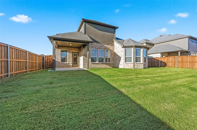 a view of a house with a big yard and large trees