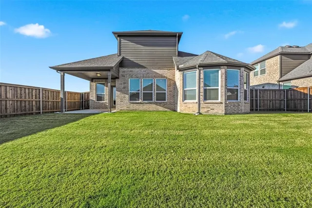 a view of a house with a yard and sitting area