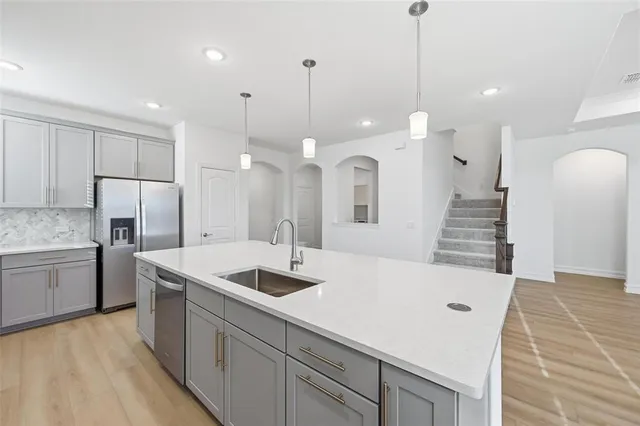 a kitchen with a refrigerator a sink and kitchen island