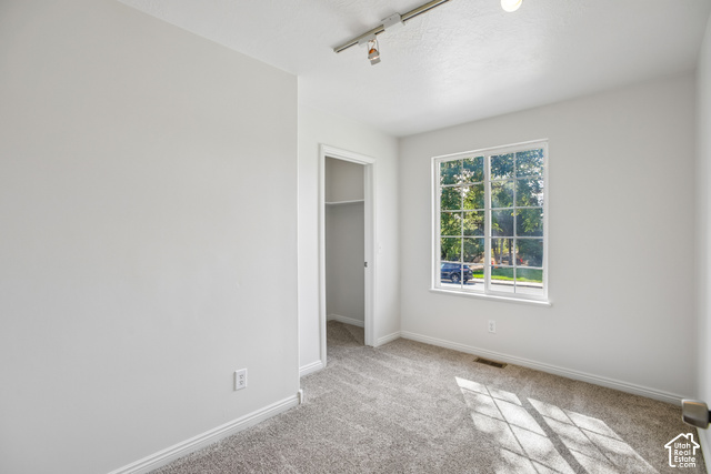 190 North 100 West Alpine, UT 84004 - Photo 19 of 31 Light gray wall paint, track lighting, carpeted flooring, a window with grid panes, and a built-in closet