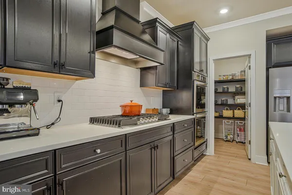 a metallic refrigerator freezer and a stove in a kitchen