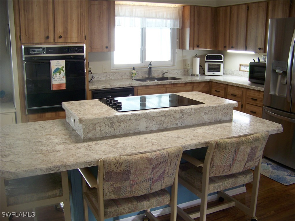 15550 Burnt Store Road, Unit 63 Punta Gorda, FL 33955 - Photo 16 of 47 a kitchen with granite countertop a sink stove and microwave