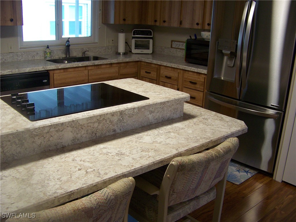 15550 Burnt Store Road, Unit 63 Punta Gorda, FL 33955 - Photo 17 of 47 a kitchen with stainless steel appliances granite countertop a sink refrigerator and microwave