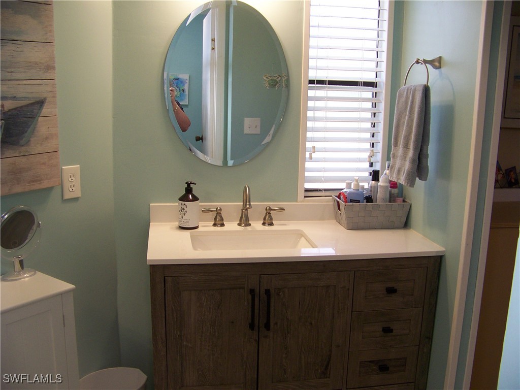 15550 Burnt Store Road, Unit 63 Punta Gorda, FL 33955 - Photo 29 of 47 a bathroom with a double vanity sink and a mirror