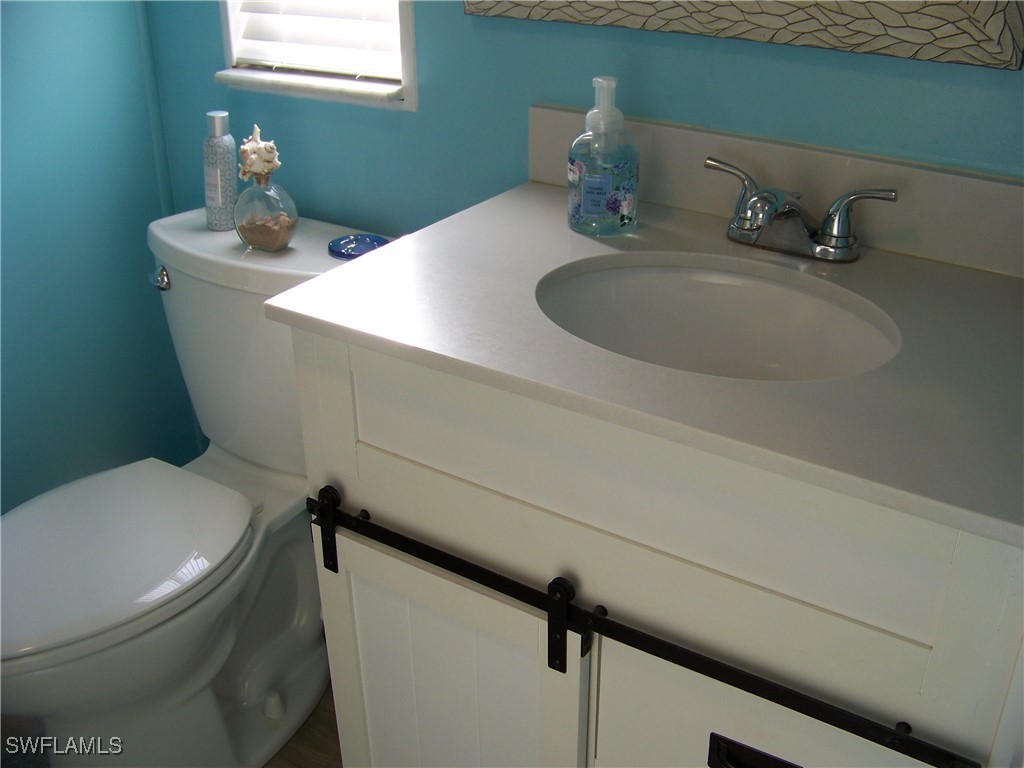 15550 Burnt Store Road, Unit 63 Punta Gorda, FL 33955 - Photo 33 of 47 a bathroom with a toilet sink and mirror