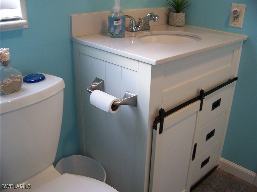 15550 Burnt Store Road, Unit 63 Punta Gorda, FL 33955 - Photo 34 of 47 a bathroom with a toilet sink and mirror