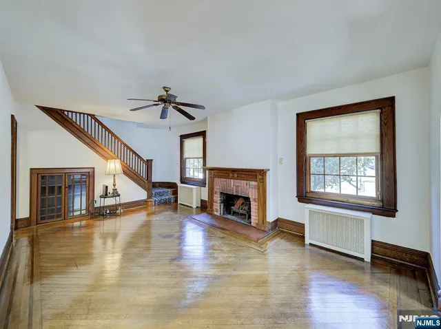 a view of a livingroom with wooden floor a fireplace and window