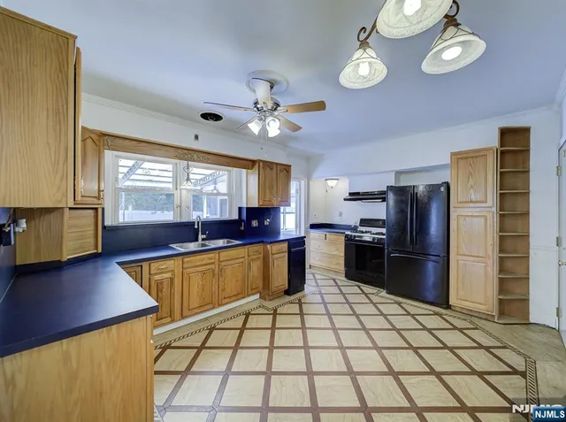 a kitchen with stainless steel appliances granite countertop a sink and a refrigerator