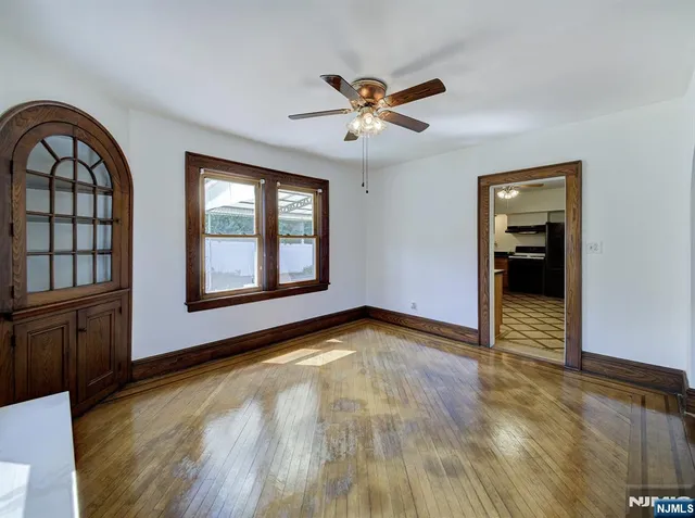 a view of an empty room with window and wooden floor