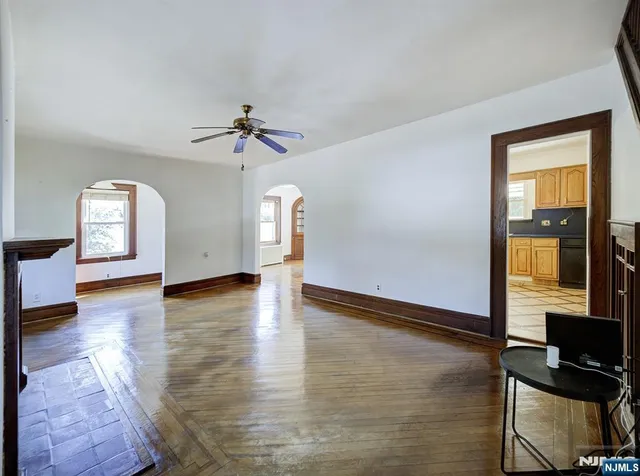 a view of an empty room with window and wooden floor