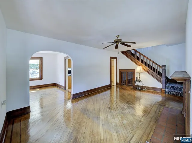 a view of a livingroom with wooden floor and a ceiling fan