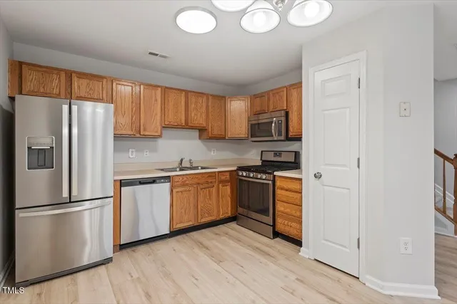 a kitchen with granite countertop a refrigerator stove top oven and sink