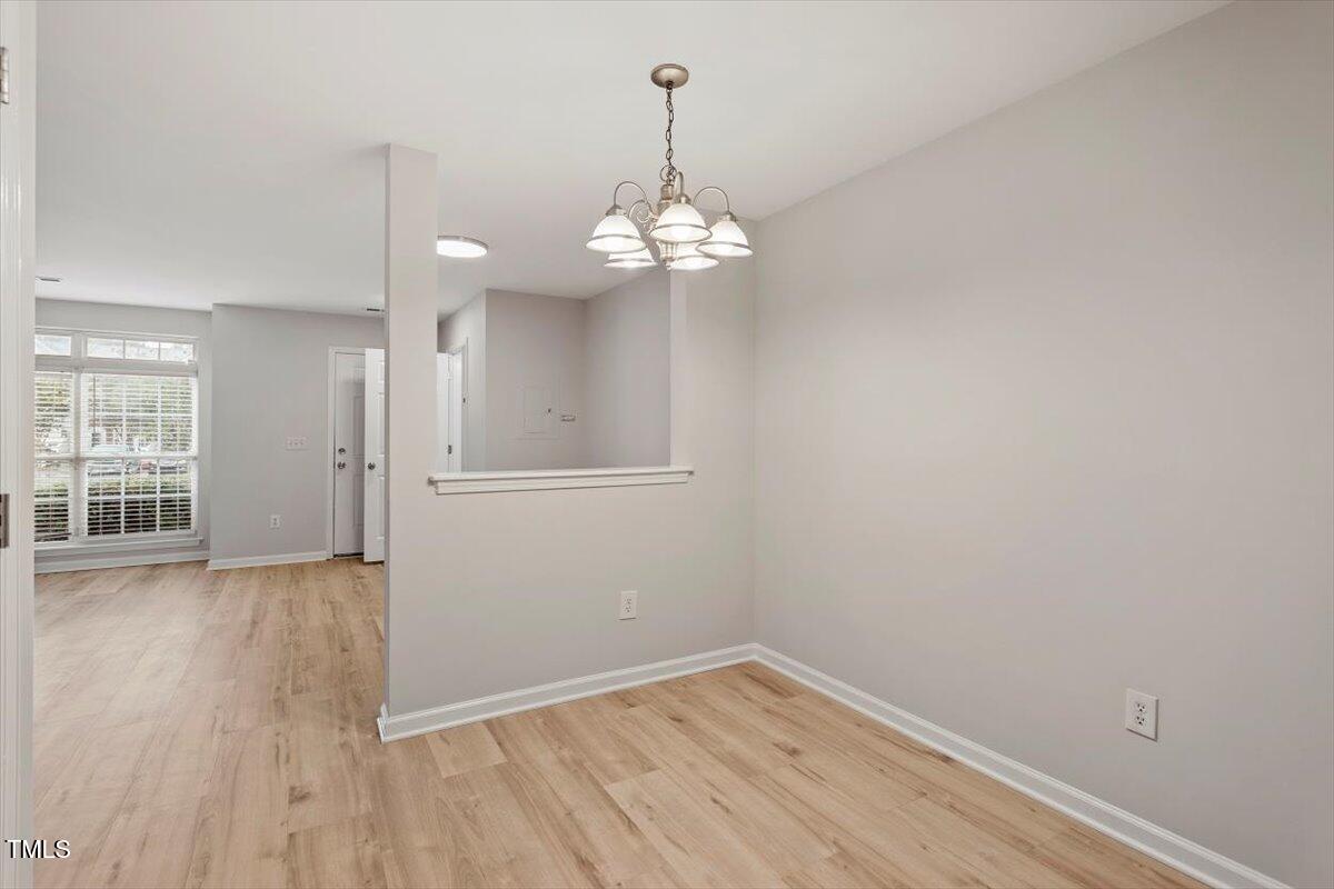 8600 Neuse Landing Lane, Unit 106 Raleigh, NC 27616 - Photo 10 of 22 wooden floor in an empty room with a window
