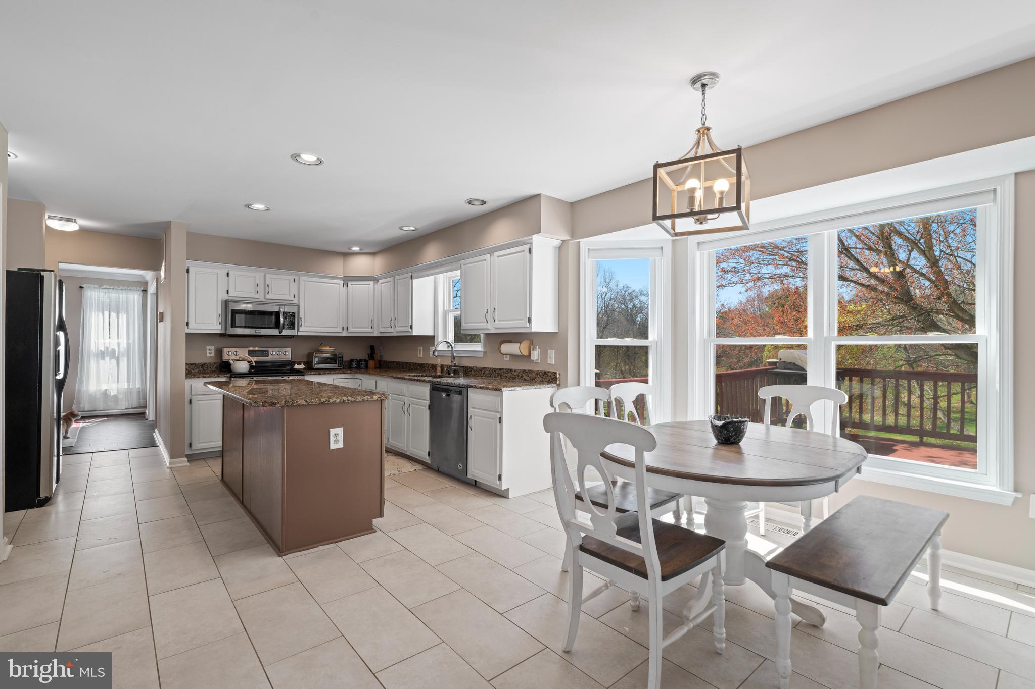 20 Farm Ridge Court Baldwin, MD 21013 - Photo 11 of 47 a kitchen with stainless steel appliances granite countertop a stove a refrigerator a kitchen island a dining table and chairs