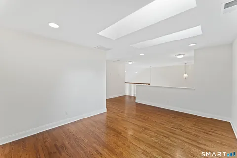 a view of empty room with wooden floor