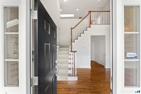 a view of entryway and hall with wooden floor
