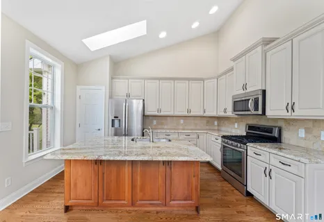 a kitchen with stainless steel appliances granite countertop a stove sink and cabinets