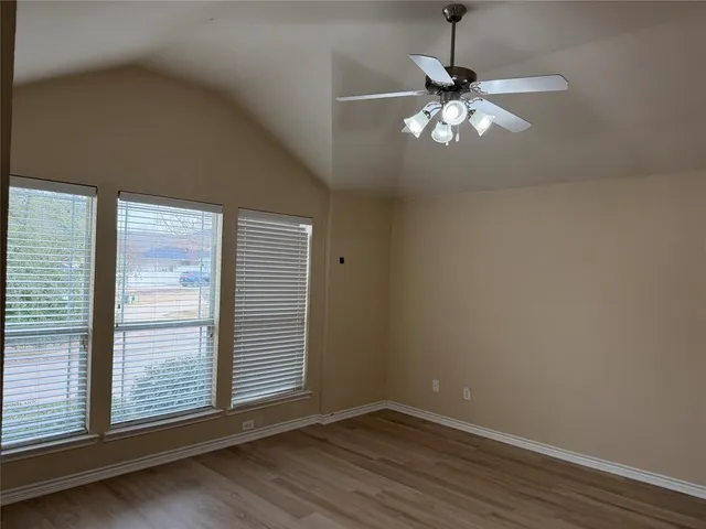 a view of wooden floor and chandelier fan in a room