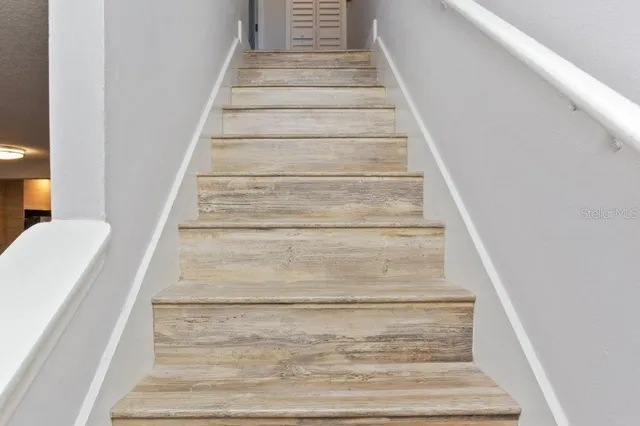 a bedroom with a bed a flat screen tv and a wall painting