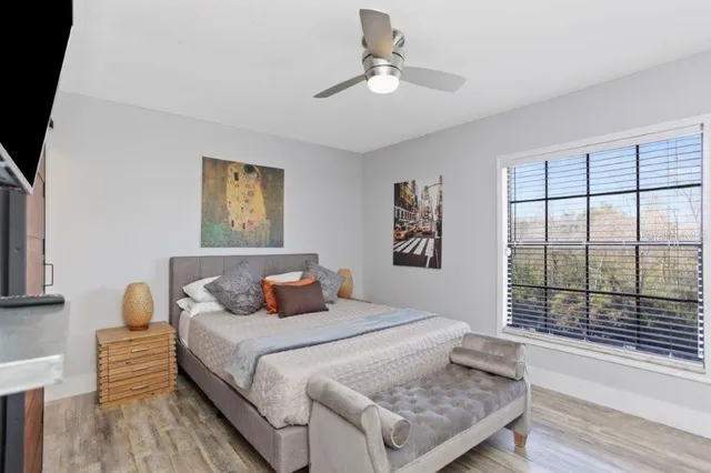 a bedroom with a bed and a painting on the wall