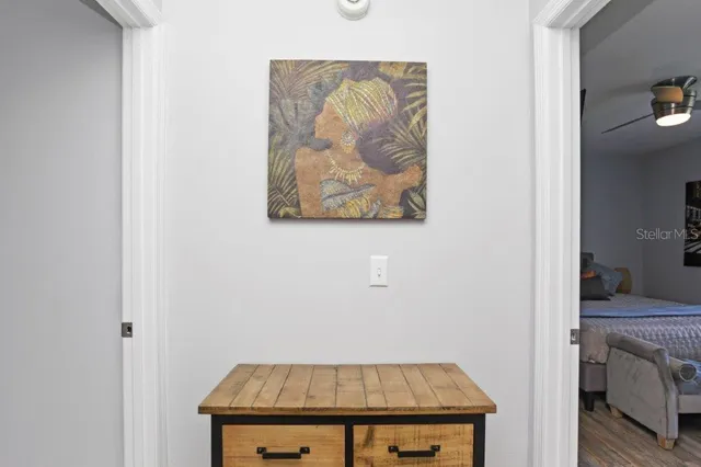 a view of empty room with wooden floor and fan