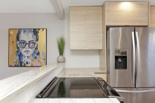 a kitchen with a sink a refrigerator and cabinets