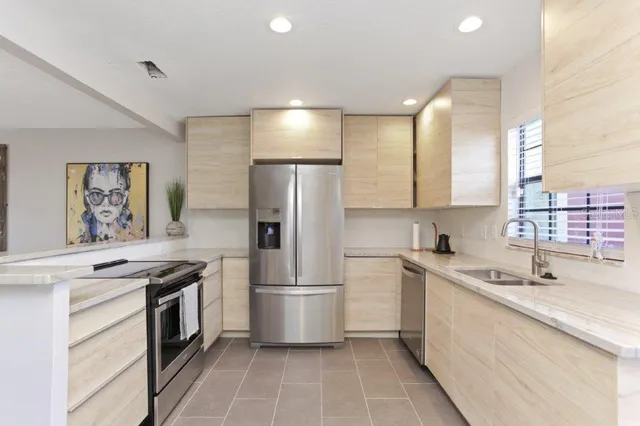 a kitchen with a sink a refrigerator and cabinets
