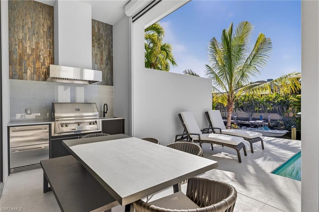1456 Curlew Avenue Naples, FL 34102 - Photo 24 of 35 a kitchen with a table chairs and a stove