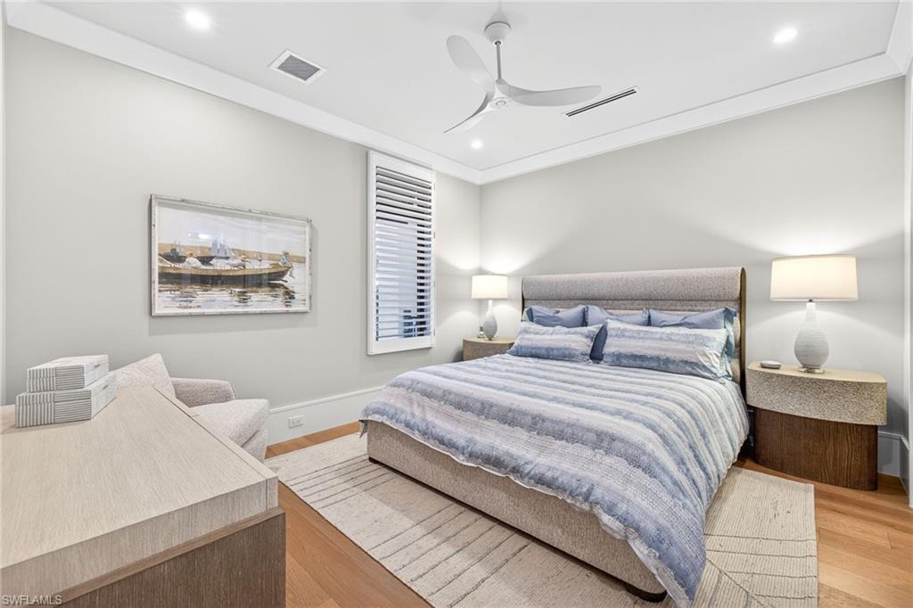 1456 Curlew Avenue Naples, FL 34102 - Photo 26 of 35 a bedroom with a large bed and a chandelier
