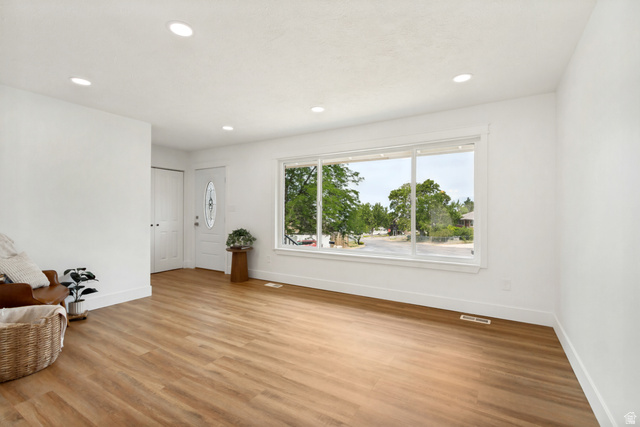 62 South Clark Lane Elk Ridge, UT 84651 - Photo 2 of 30 Bright interior space featuring a large picture window, LVP flooring, recessed lighting, white baseboards, and a white entry door with an oval glass insert