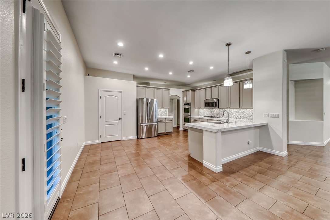2122 Mooreview Street Henderson, NV 89012 - Photo 6 of 44 An open-concept living space with sleek cabinetry and warm-toned flooring.