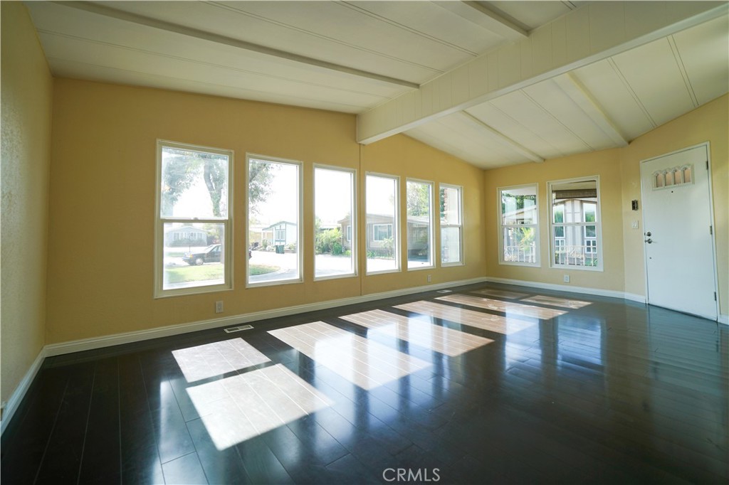 1919 West Coronet Avenue, Unit 190 Anaheim, CA 92801 - Photo 6 of 31 a view of an empty room with wooden floor and a window