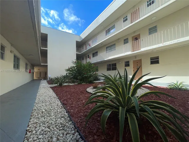 a view of a balcony with a floor to ceiling window and palm tree