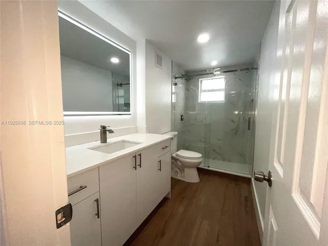 a bathroom with a double vanity sink toilet and shower
