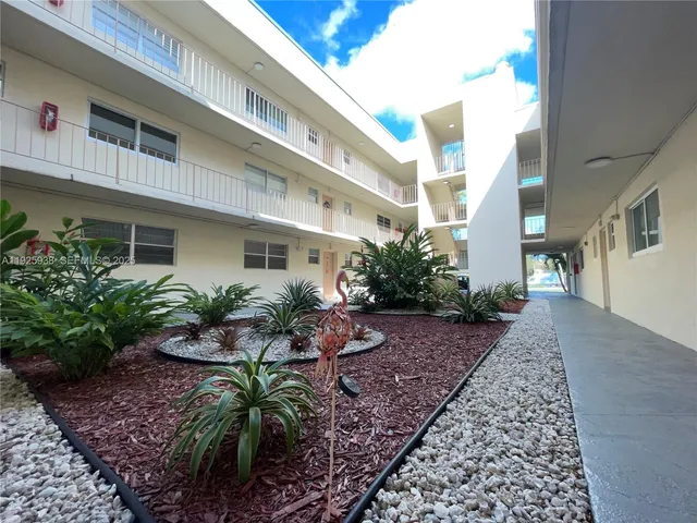 a backyard of a house with potted plants and wooden walls