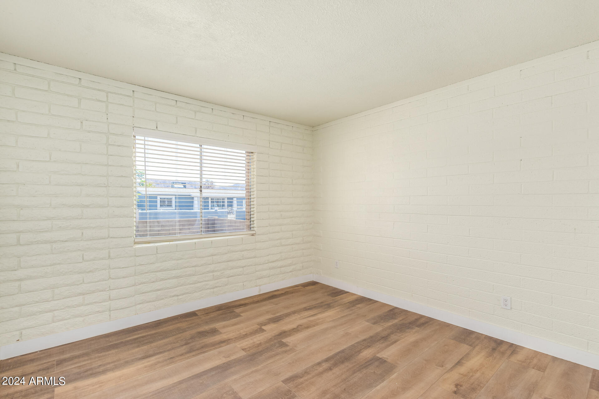 1528 West Maldonado Road Phoenix, AZ 85041 - Photo 11 of 19 an empty room with wooden floor and windows
