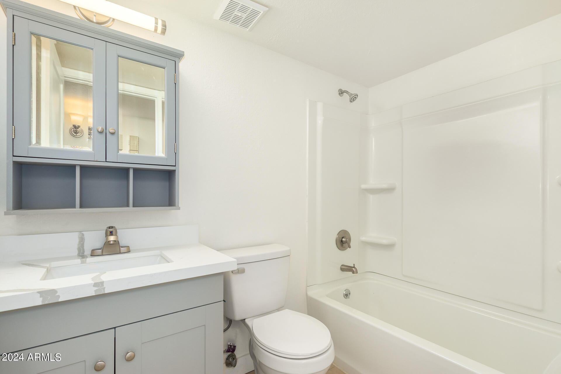 1528 West Maldonado Road Phoenix, AZ 85041 - Photo 13 of 19 a bathroom with a bathtub shower sink vanity mirror and toilet