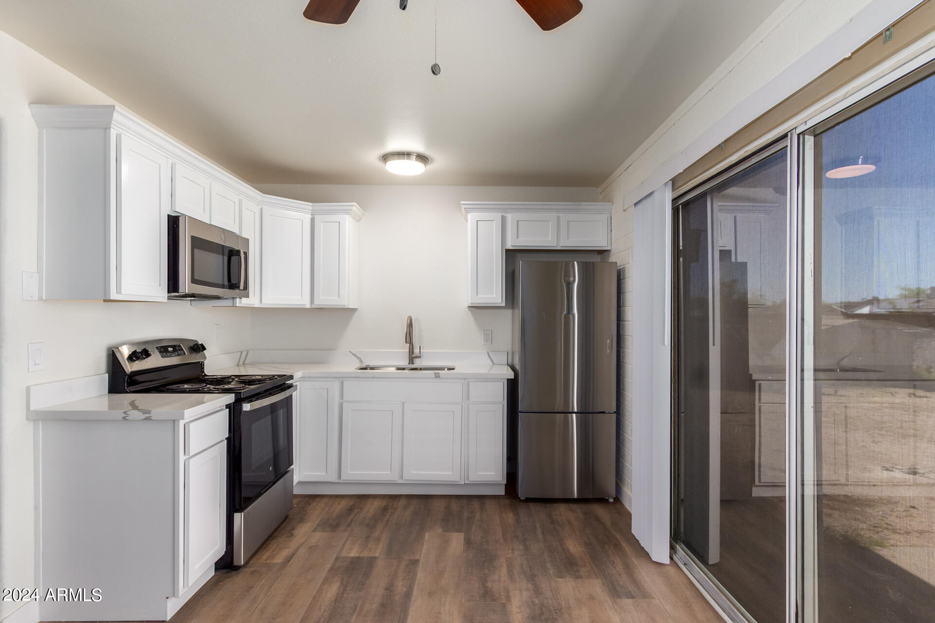 1528 West Maldonado Road Phoenix, AZ 85041 - Photo 7 of 19 a kitchen with a refrigerator a sink and wooden floor
